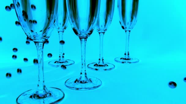 Falling White Pearls Next Wine Glasses Blue Background Slow Motion — Video Stock