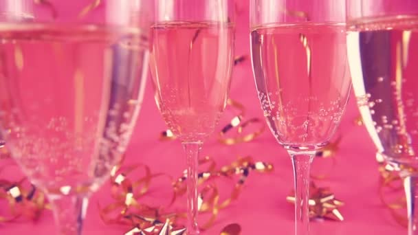 Falling Confetti Glasses Sparkling Wine Pink Background Serpentine Slow Motion — Vídeo de Stock