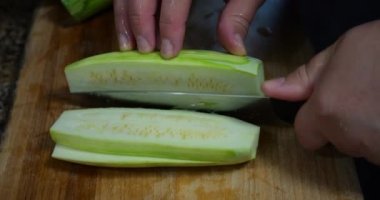 Slicing zucchini on a cutting board.
