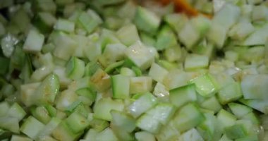 Cooking slices of zucchini in a pan.