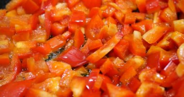 Cooking red sweet pepper in a frying pan.