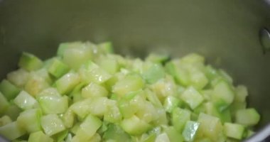 Braised zucchini slices in a saucepan.