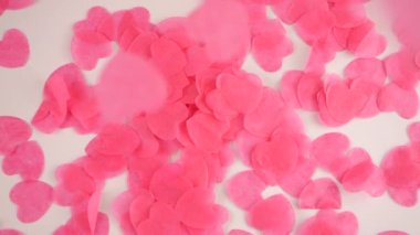 Falling confetti on a white background. Slow motion.