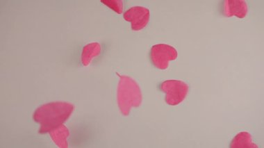 Falling confetti on a white background. Slow motion.
