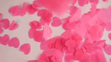 Falling confetti on a white background. Slow motion.