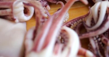 Tentacles and carcass of boiled squid on a cutting board.