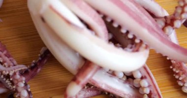 Tentacles and carcass of boiled squid on a cutting board.