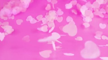 Flying confetti on a pink background. Slow motion.