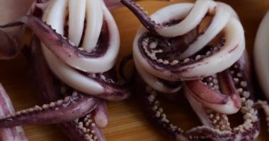 Tentacles and carcass of boiled squid on a cutting board.