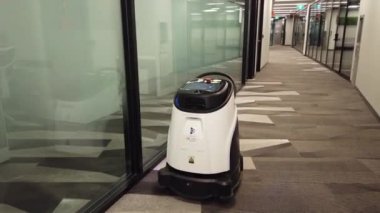 Robot vacuum cleaner cleans in the corridor of an office building. University of Toronto, Toronto, Ontario, Canada
