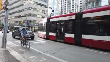 Modern trams, skyscrapers, streets and pedestrian crossing in downtown Toronto, Ontario, Canada.