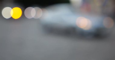 The light from the headlights of cars on the evening road of the city. Out of focus.