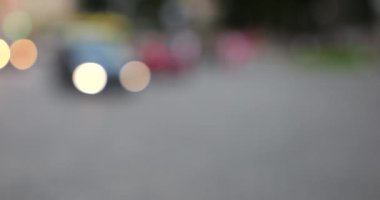 The light from the headlights of cars on the evening road of the city. Out of focus.