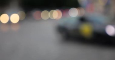 The light from the headlights of cars on the evening road of the city. Out of focus.