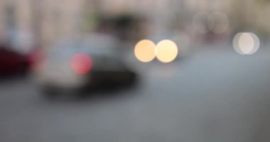 The light from the headlights of cars on the evening road of the city. Out of focus.