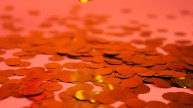 Falling serpentine streamer on confetti on a pink background. Slow motion.
