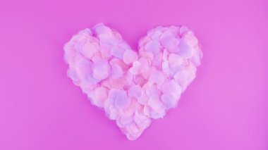 Heart-shaped confetti flies in the wind. Slow motion.