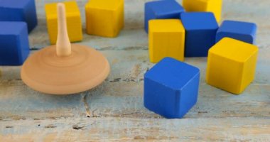 Peg oyuncağı ya da girdap oyuncak bloklarının arka planında eski bir tahta üzerinde döner..