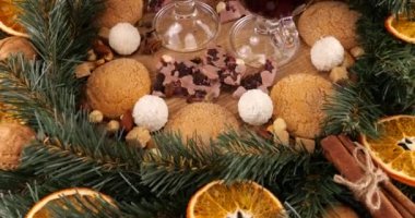 Sıcak şarap, kozalaklı dallardan, portakal dilimlerinden ve tatlılardan oluşan bir çelenk ile Noel temalı şenlik kompozisyonu.