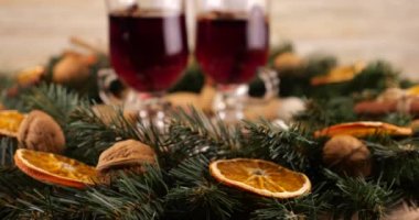 Sıcak şarap, kozalaklı dallardan, portakal dilimlerinden ve tatlılardan oluşan bir çelenk ile Noel temalı şenlik kompozisyonu.