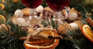 Sıcak şarap, kozalaklı dallardan, portakal dilimlerinden ve tatlılardan oluşan bir çelenk ile Noel temalı şenlik kompozisyonu.
