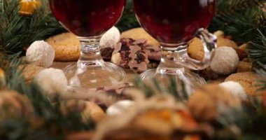 Sıcak şarap, kozalaklı dallardan, portakal dilimlerinden ve tatlılardan oluşan bir çelenk ile Noel temalı şenlik kompozisyonu.