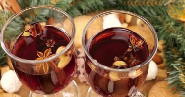 Sıcak şarap, kozalaklı dallardan, portakal dilimlerinden ve tatlılardan oluşan bir çelenk ile Noel temalı şenlik kompozisyonu.