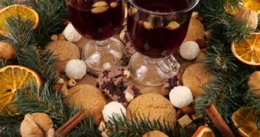 Sıcak şarap, kozalaklı dallardan, portakal dilimlerinden ve tatlılardan oluşan bir çelenk ile Noel temalı şenlik kompozisyonu.
