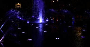 Gece şehrinde fıskiyenin su fıskiyeleri.