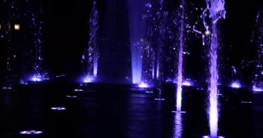 Gece şehrinde fıskiyenin su fıskiyeleri.