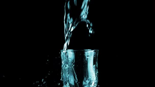 Vattenstråle Hälls Glasbägare Svart Bakgrund Och Skapar Ett Stänk Vatten — Stockvideo