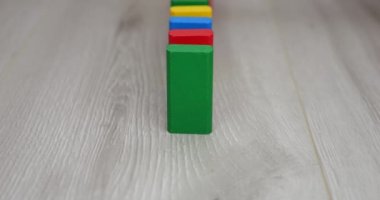 Çocukların tahta oyuncak blokları domino etkisi altında düşer. Yavaş çekim.