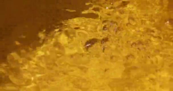 オレンジ色の抽象的な反射の背景に水と泡を走らせトップビュー — ストック動画