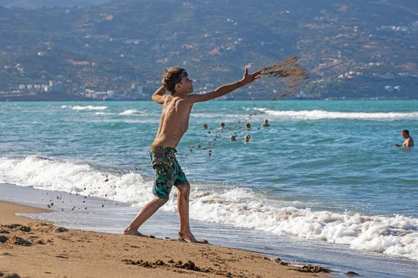 Χαρούμενο Αγόρι Ρίχνει Άμμο Στην Παραλία Κατά Διάρκεια Μιας Καταιγίδας — Φωτογραφία Αρχείου