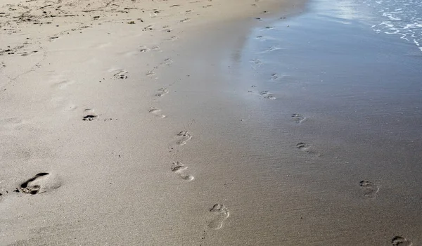 Deniz Kıyısındaki Kumsaldaki Islak Kumda Yatay Ayak Izlerinin Soyut Arkaplanı — Stok fotoğraf
