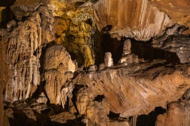 Yeraltındaki bir mağarada sarkıtların, dikitlerin ve dikdörtgenlerin soyut arkaplanı.