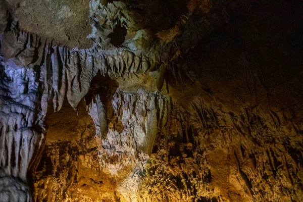 Yeraltındaki bir mağarada sarkıtların, dikitlerin ve dikdörtgenlerin soyut arkaplanı.