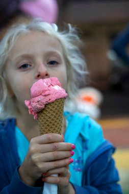 Elindeki waffle külahından leziz bir dondurma topunu tut, yatay olarak.