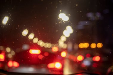 Soyut, bulanık arkaplan, arabanın ön camında bir damla yağmur, yatay.