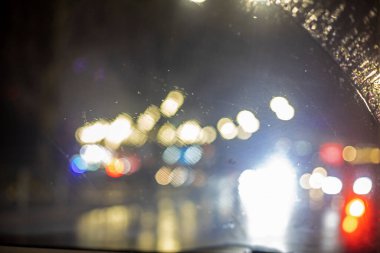 Soyut, bulanık arkaplan, arabanın ön camında bir damla yağmur, yatay.