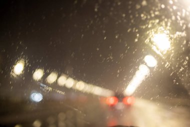Soyut, bulanık arkaplan, arabanın ön camında bir damla yağmur, yatay.