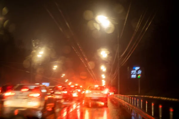 雨の中交通渋滞の中車のフロントガラスの抽象的なぼやけた背景 — ストック写真