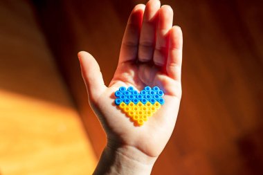 Küçük çocukların elleri avucunun içinde Ukrayna bayrağı bomba sığınağında kalp şeklinde, Ukrayna 'da savaş yok, yatay