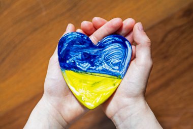 Çocuk elleri Ukrayna 'nın mavi-sarı kalbini tutar, Ukrayna' yı korur.