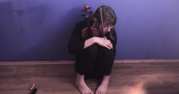 年轻的小提琴手因小提琴演奏不成功而心烦意乱 她坐在地板上搂着乐器 心烦意乱 — 图库视频影像