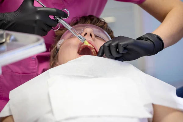 doctor makes an injection in a sick tooth to a patient, modern dental technology