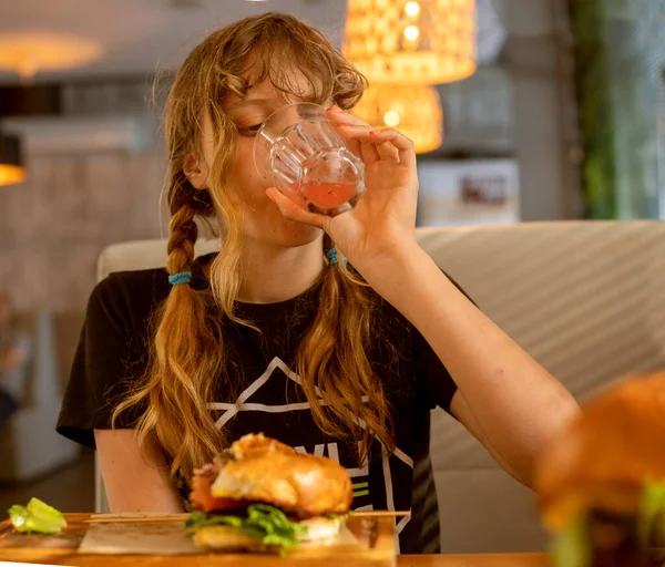 Tenager Girl Bebe Limonada Sandía Come Una Hamburguesa Con Chuleta — Foto de Stock