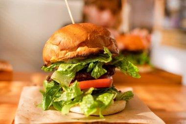 Domuz pirzolası, marul, domates ve turşulu sıcak hamburger. Yaz günü