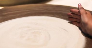Elinizin tersiyle çömlekçinin tekerinde kum deseni oluşturun. Aktif aile tatili, hobi, yaratıcılık
