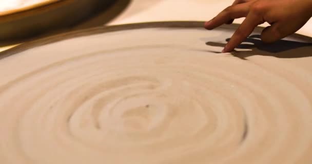 陶工の車輪の上の子供の指は砂の上にパターンを作成します アクティブな家族の休暇 — ストック動画